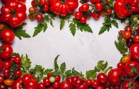 Various fresh tomatoes with green leaves. Top viewの写真素材