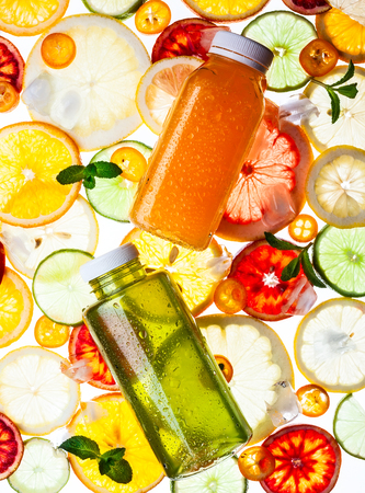 Bottles of fresh juice on the citrus background. Transparent pattern.の写真素材
