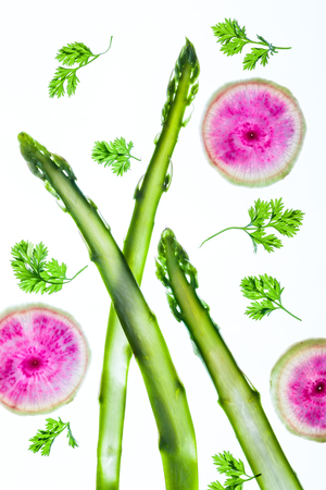 Thin slices of fresh vegetables on a white backgroundの写真素材