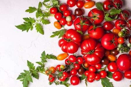 Various fresh tomatoes with green leaves. Top viewの写真素材
