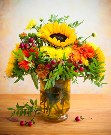 autumnal flowers and berries in a vaseの写真素材