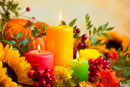 Autumn concept with burning colorful candles and flowersの写真素材