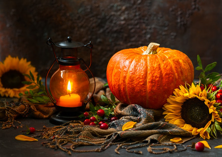 Autumn still life with pumpkin, sunflowers and burning candleの写真素材