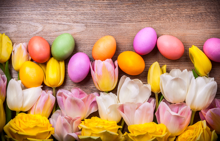 Colorful tulips and Easter eggs on old wooden background. Festive  Easter concept with copy space. Flat layの写真素材