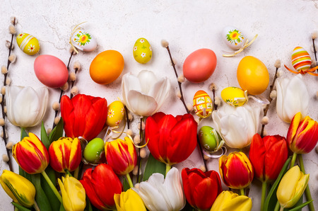 Colorful tulips with branches pussy willows and easter eggs on old table.の写真素材