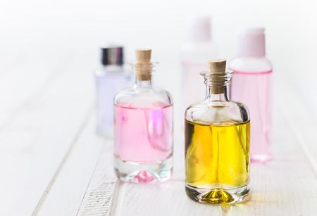 Bottles with essential aroma oil on white wooden background.Healthy skin care. Place for text.の写真素材