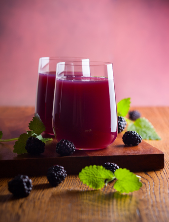 Fresh blackberry juice in glasses with mint and fresh berries on the wooden table.の写真素材