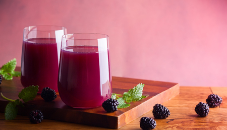Fresh blackberry juice in glasses with mint and fresh berries on the wooden table.の写真素材