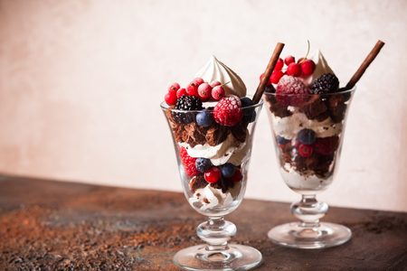 Chocolate brownies, fresh berries,meringue and whipped cream layered in glasses. Delicious summertime dessert.の写真素材