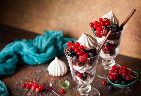 Chocolate brownies, fresh berries,meringue and whipped cream layered in glasses. Delicious summertime dessert.の写真素材