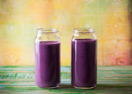 Fresh blackberry and blueberry smoothie in glass bottlesの写真素材