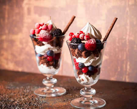 Chocolate brownies, fresh berries,meringue and whipped cream layered in glasses. Delicious summertime dessert.の写真素材
