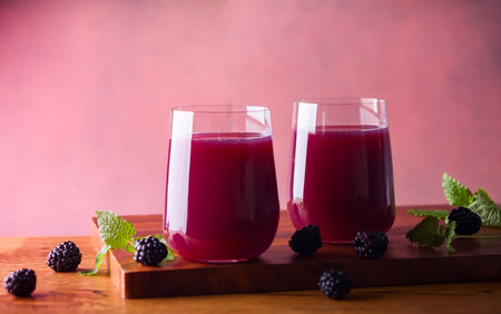 Fresh blackberry juice in glasses with mint and fresh berries on the wooden table.の写真素材