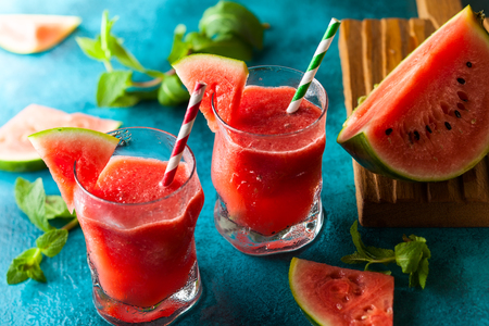 Summer refreshing watermelon drink in glasses with mint and drinking strawの写真素材