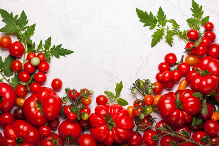 Various fresh tomatoes with green leaves. Top viewの写真素材