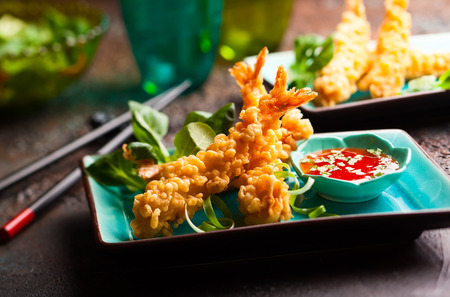 Shrimps tempura with spicy chili sauce on blue plate.  Seafood tempura dish of traditional asian cuisine .の写真素材