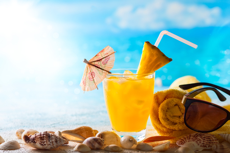 Summer concept: fresh exotic cocktail and sunglasses on the beachの写真素材