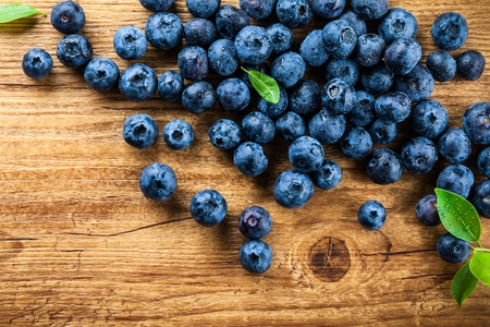 Fresh blueberry with drops of water on wooden background. Top view. Concept of healthy and dieting eatingの写真素材