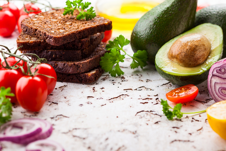 Fresh ingredients for making healthy vegetarian sandwiches with black bread,avocado and tomatoes. Concept healthy eating.の写真素材