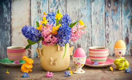 Easter breakfast table with tea,eggs in egg cups, spring flowers in vase and Easter decorの写真素材