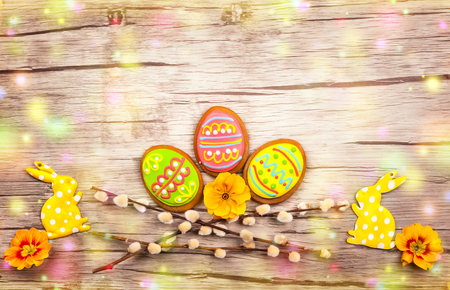 Easter composition with spring flowers and easter cookies on wooden background. Easter concept with...