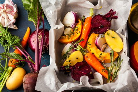 Preparing  roasted vegetables with garlic and herbs on the baking tray. Autumn-winter root vegetables.の写真素材
