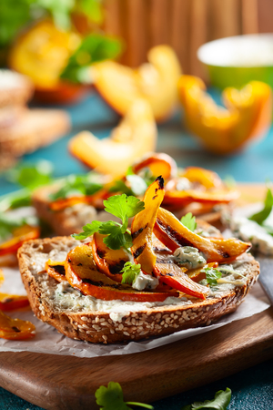 Open sandwich with grilled pumpkin and soft cheese  on multigrain rye bread.の写真素材