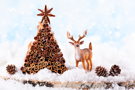 Christmas holiday concept with deer, pine cone and Christmas tree made from stock of cinnamon and anise star.の写真素材