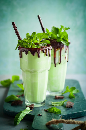 Mint chocolate milkshake with ice cream and fresh mint leaves in glassの写真素材