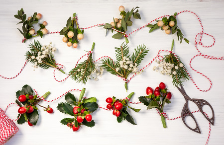 Making natural Christmas  garlands  with fresh flowers,leaves,berries and fir branches.の写真素材