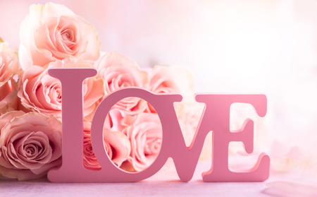 Festive still life with pink roses and word "Love".の写真素材