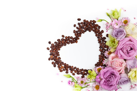 Festive concept for Valentine day or Mother's day with flowers and coffee beans in shape of heart on white background. Valentine day greeting card, top view, flat lay.の写真素材