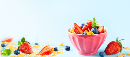 Concept of healthy gluten free breakfast with berries, natural yogurt and corn flakes in the pink...