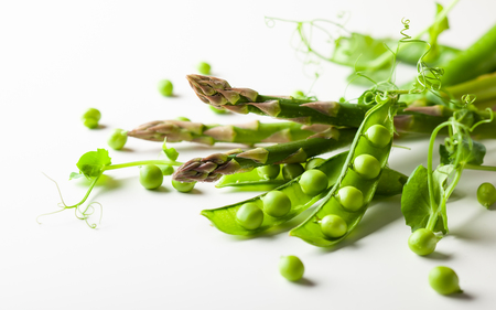 Fresh green  peas pods  with  sprouts and green asparagus on white woodenの写真素材