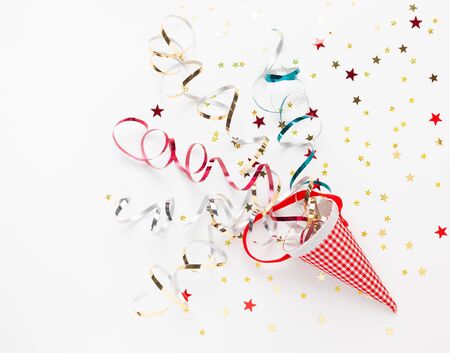 Festive composition with colorful confetti, Christmas ornaments and streamers on white. Celebration concept ideas for Christmas, New Year. Flat lay, copy space.の写真素材