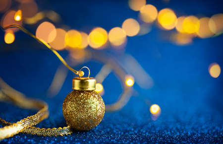 Christmas or New Year festive background with Christmas gold baubles on glitter blue backdrop....