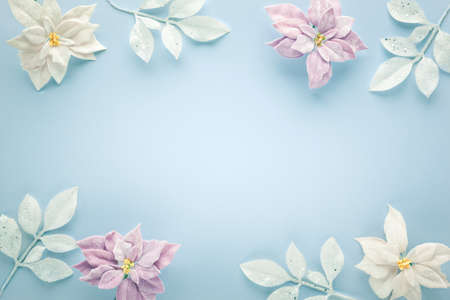 Christmas arrangement with poinsettia flowers and silver leaves on pastel background. Flat lay. Top...