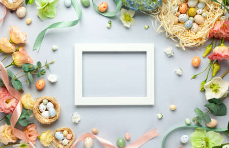 Happy Easter concept with easter eggs in nest and spring flowers. Easter background with copy space....