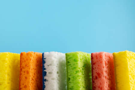 Household Cleaning Scrub Colored Sponges. Kitchen Dishwashing Sponge on blue background. Cleaning...