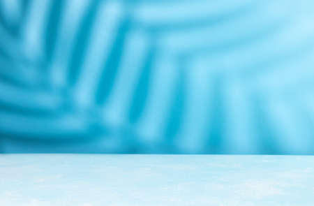 Abstract shadow on table top and blue wall Blurred backdropの写真素材