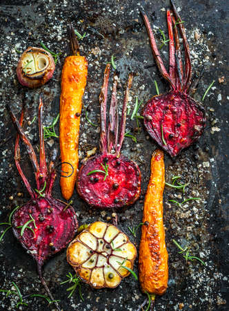 Roasted carrots and beetroot on a baking trayの写真素材