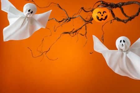 Halloween ghosts with funny pumpkin on orange background. Happy halloween holiday concept. Handmade...
