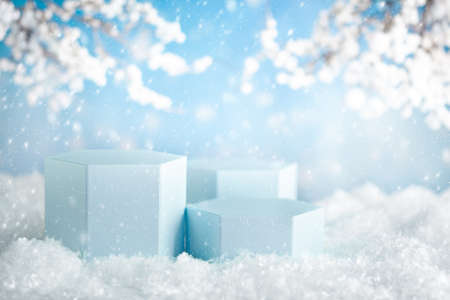 Winter composition with light blue podiums for product presentation in snowy background. Christmas, New Year and winter holiday concept.の写真素材