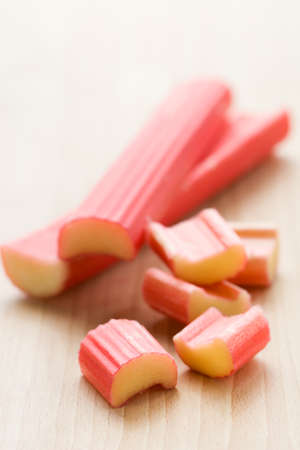 fresh rhubarb sticks and pieces on the wooden table