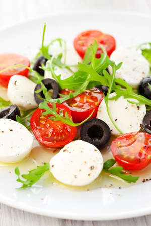 Caprese salad with mozzarella, tomatoes and black oliveの写真素材
