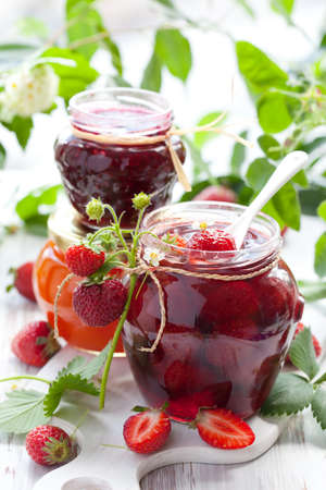 strawberry, apricot, raspberry jam in a jars and fresh berries