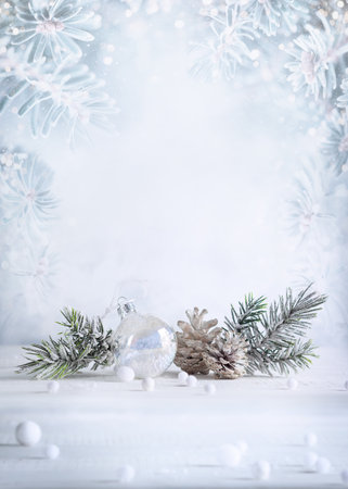 Christmas still life with snowy pine cones, baubles and fir branches on light background. Winter or Christmas holiday concept.の写真素材