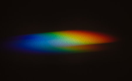 Rainbow reflective colorful sunlight on textured surface of wall. Dispersion and refraction of light.の写真素材