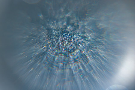 Dynamic abstract blue background with radiant light burst, shimmering texture, and soft sparkling...