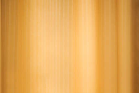 The shadow of the transparent curtains on a gold wall. Blurred curtains background texture design